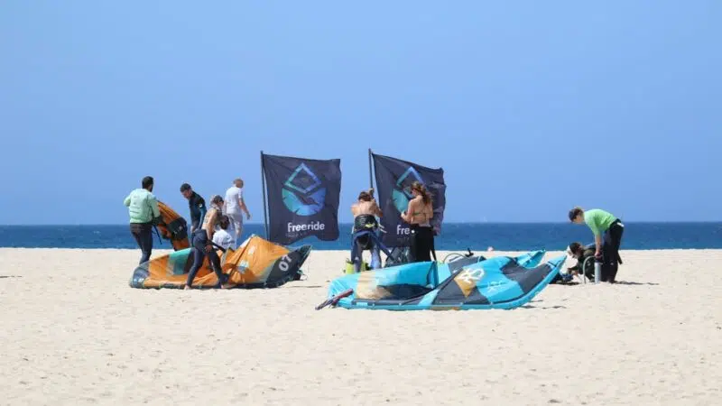 Student learning how to inflate the kite and connect the four lines during IKO Level 1 equipment setup in Tarifa.