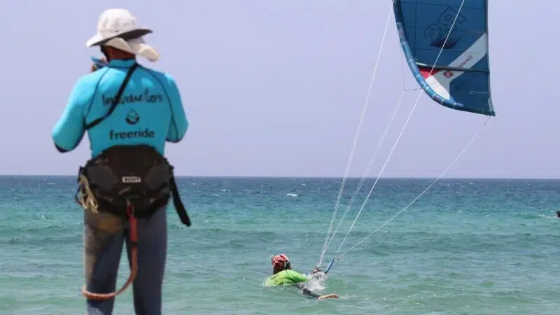 Alumno de kitesurf practicando bodydrag en aguas profundas durante la etapa intermedia del curso IKO Nivel 2 en Freeride Tarifa.