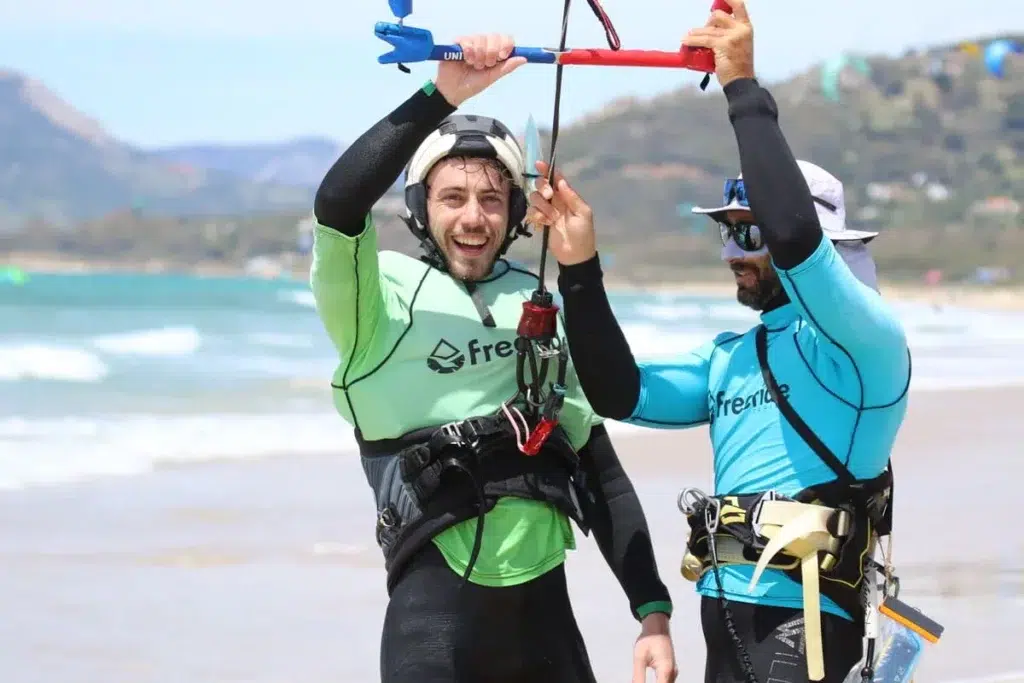 Un kitesurfista practicando kitesurf en Tarifa en otoño, durante una soleada tarde de septiembre, con la playa de Los Lances al fondo.